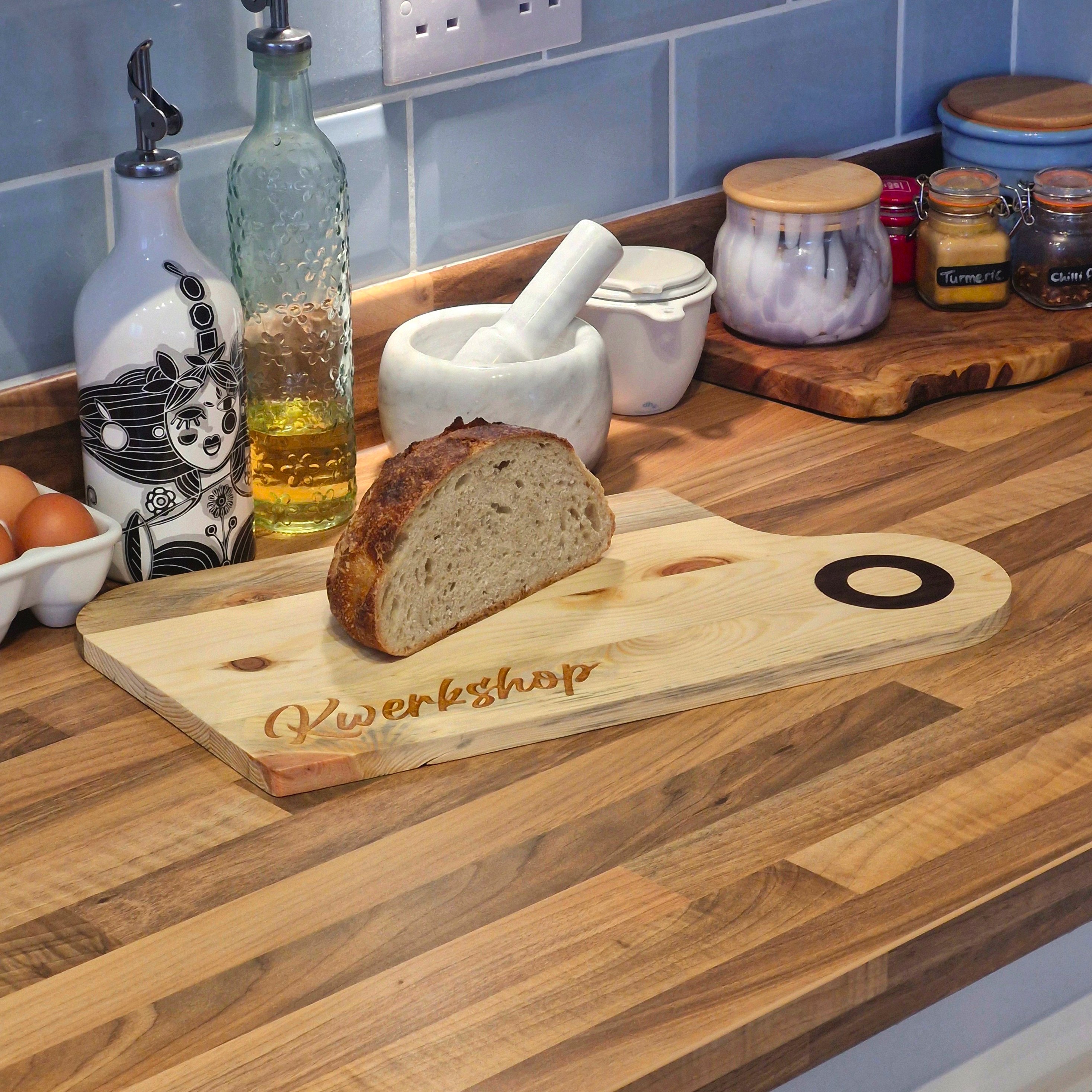a long shot of a chopping board on a kitchen worktop with bread on it